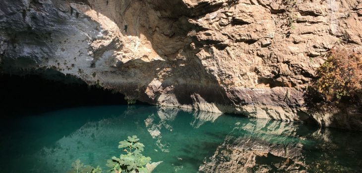 Glasklares Wasser im See der Altinbesik-Höhle mit Spiegelungen der Felsen.